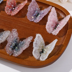 Detailed close-up of butterfly fabric patches with shimmering crystals for DIY jewelry crafts