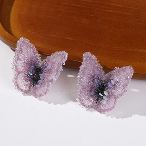 Close-up of pink-purple gradient fabric butterfly with glittering rhinestones and beads