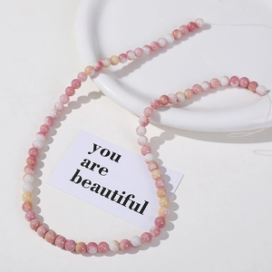 Detail of 8mm pink and white marble pattern beads for DIY jewelry making and crafts