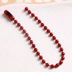 Macro detail of red painted ball chain with metal connector for DIY jewelry projects
