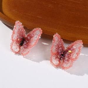 Detailed macro view of glitter butterfly charms with pink gradients and sparkly crystals