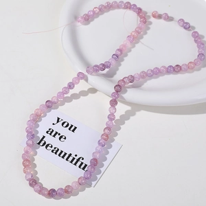 Macro detail of 8mm purple and pink crackle quartz beads for DIY jewelry making