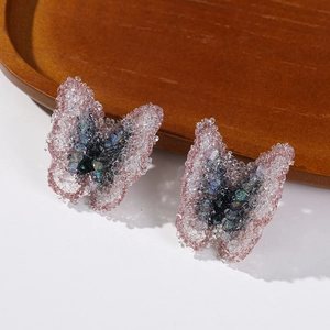 Detail of pink butterfly fabric patches with shimmering rhinestones and iridescent wing texture