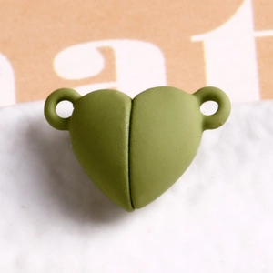 Macro view of avocado green matte heart magnetic clasp connector for DIY jewelry