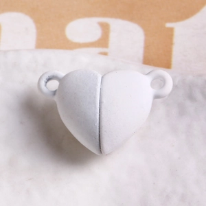 Macro shot of matte white heart magnetic clasp for DIY bracelet and jewelry making