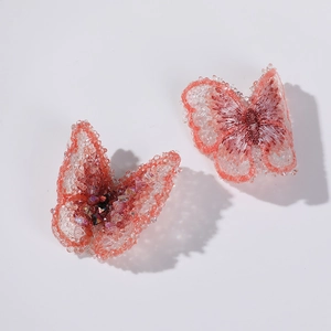 Detail of handmade butterfly hair clip with pink embroidery and sparkling crystal beads