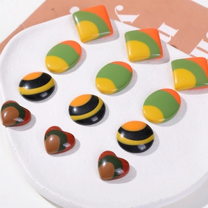 Polished resin DIY accessory charms in colorful geometric shapes on a white ceramic plate