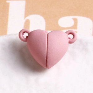 Macro view of pink heart-shaped magnetic clasp with a matte finish for jewelry DIY