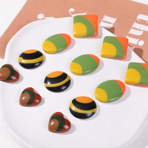 Macro detail of geometric resin cabochons in striped colorful heart and oval shapes