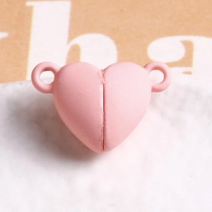 Macro view of light pink heart-shaped magnetic clasp for DIY jewelry making and connectors