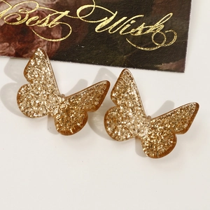 Macro shot of glitter butterfly hair accessories on a gift card with golden foil