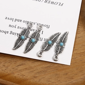 Détail de breloques plumes en argent antique avec perles bleues pour bijoux DIY
