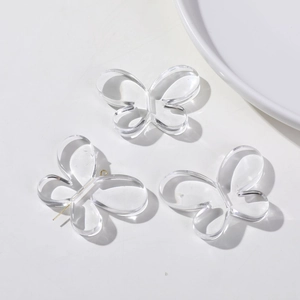 Pendentifs papillons en acrylique transparent pour boucles d'oreilles sur plateau blanc