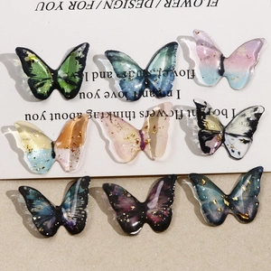 Detailed view of nine handmade resin butterfly charms with gold foil and gradient colors