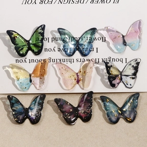 Close-up of DIY resin butterfly charms with gold foil and gradient translucent colors