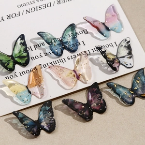 Macro shot of 9 colorful resin butterfly DIY charms with gold foil and gradient texture