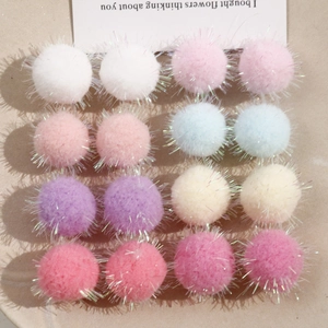 Detailed view of colorful plush pom poms with glitter thread for DIY jewelry making