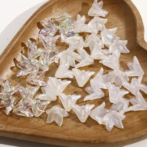 Vista macro di perle a forma di fiori iridescenti in un vassoio di legno