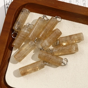 Macro view of cylindrical natural stone pendants with silver rings and crystal inclusions