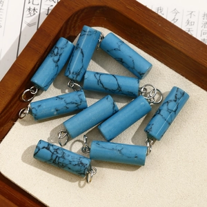 Detail of blue turquoise cylinder charms with silver jump rings for DIY jewelry making