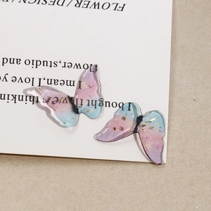 Close-up of DIY resin butterfly charms with gold foil and blue-purple gradient