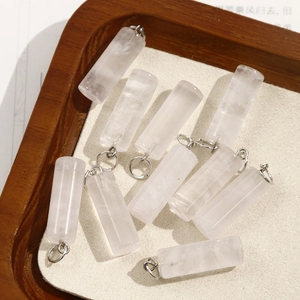 Macro shot of 11 cylindrical pink quartz stone pendants with silver metal loops for DIY jewelry