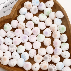 Macro detail of colorful flocked cat paw beads for DIY jewelry in a heart-shaped tray
