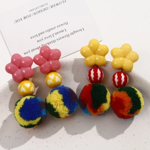 Detail view of colorful 30mm plush pom-pom earrings with floral studs and striped beads