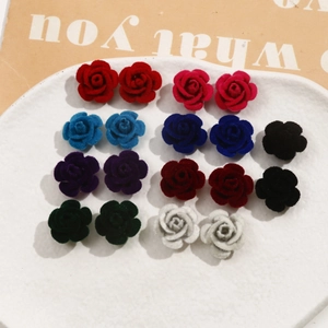 Detalle de 18 pétalos de rosa flocados de colores en una bandeja de cerámica blanca