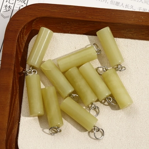 Macro detail of ten light green natural stone cylinder pendants for DIY jewelry making