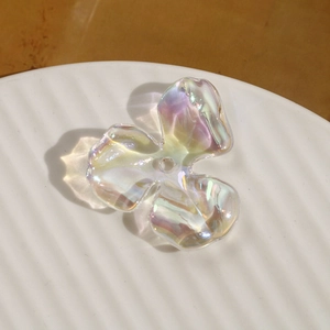 Close-up of iridescent acrylic three-petal flower beads for DIY jewelry making