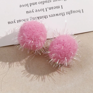 Macro shot of pink fluffy pom poms with glittery colorful tinsel for DIY jewelry making