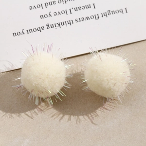 Detail of creamy white plush pom-pom charms with iridescent tinsel for DIY jewelry making