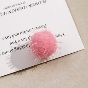 Macro view of fluffy pink plush craft balls with shimmering iridescent tinsel threads