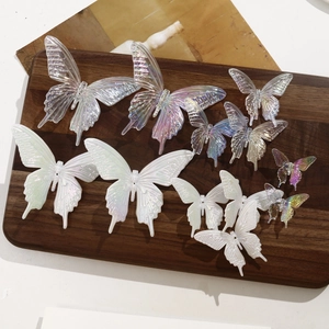 Macro view of iridescent resin butterfly charms in various sizes for hair accessory DIY