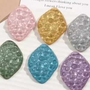 Macro view of colorful diamond resin charms with honeycomb texture and glitter finish