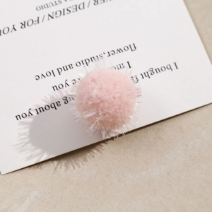 Macro shot of a pink plush pom pom with sparkling fibers for DIY jewelry and hair accessories