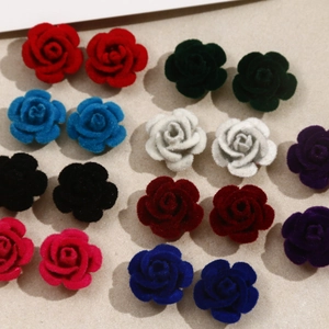 Detalle de pendientes de rosa 3D en terciopelo en colores rojo, verde y azul