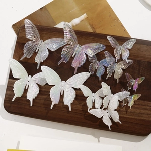 Detailed view of iridescent butterfly DIY resin accessories on a vintage wood board