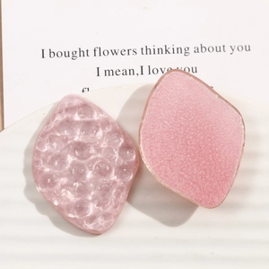 Detail showing two light pink resin leaf hair clips with ripple and matte textures