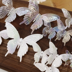 Macro detail of large iridescent resin butterfly charms for DIY hair accessories and crafts