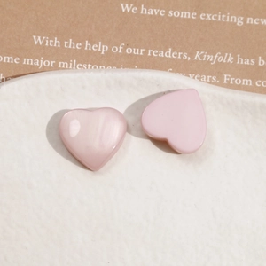 Detailed view of pink resin heart charms with cat eye effect on a decorative plate