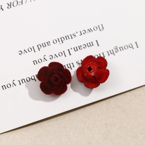 Detalle macro de dijes de rosas flocadas rojo oscuro para joyas DIY con agujero trasero