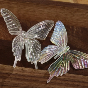 Macro view of iridescent 3D resin butterfly charms with colorful aurora coating for hair accessories