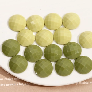 Dettaglio di ciondoli geometrici in resina sfaccettata verde oliva e lime per gioielli