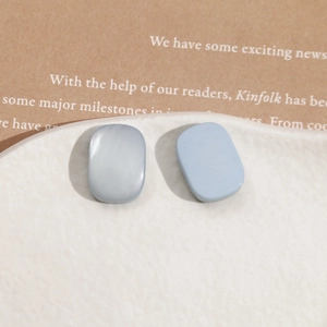Detail shot of light blue square resin earrings on a white textured ceramic plate