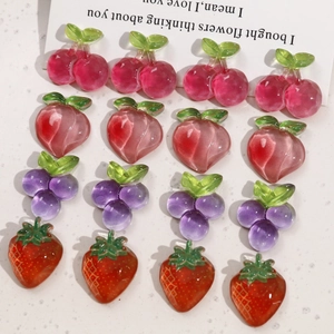 Macro detail of transparent resin fruit charms including strawberry and grape for DIY crafts