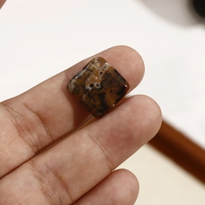 Macro-opname van vierkante bruine natuursteen kraal met zwarte spikkels voor DIY sieraden
