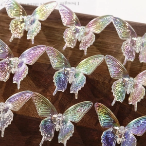 Macro detail of iridescent butterfly acrylic beads with colorful gradient on wood surface