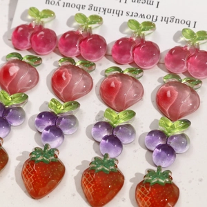 Flat lay of translucent resin fruit charms including cherry, peach and strawberry